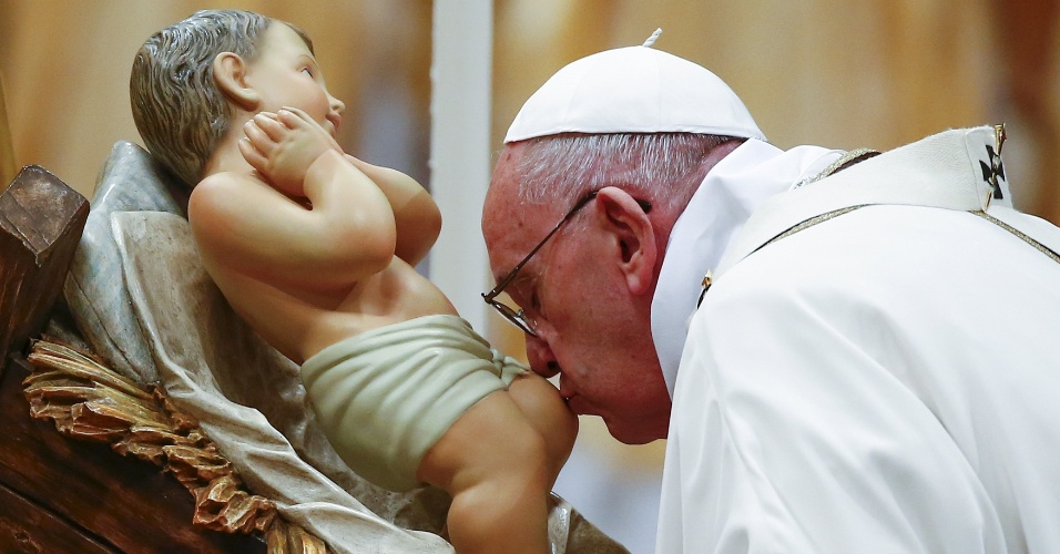 24.dez.2015 - Papa Francisco beija estátua do menino Jesus enquanto conduz a missa da noite de Natal na Basílica de São Pedro, no Vaticano