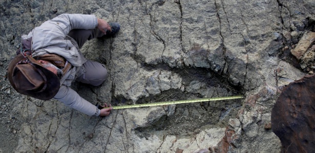O paleontólogo Sebastian Apesteguia mede uma pegada feita por um dinossauro carnívoro há 80 milhões de anos. A pegada de 1,20 metro de diâmetro foi encontrada na cratera de Maragua, na Bolívia - David Mercado/Reuters