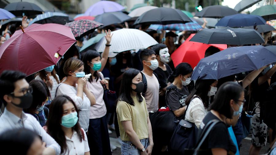 Manifestantes com máscaras fazem barricadas no centro do distrito comercial de Hong Kong  - Jorge Silva/Reuters
