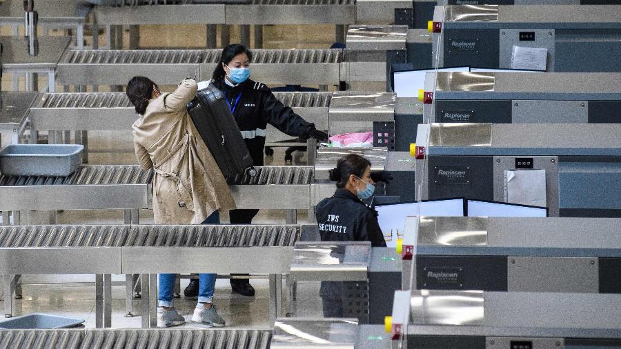 Membros da segurança usam máscaras faciais dentro da estação de trem de alta velocidade que conecta Hong Kong à China continental.  A China pediu aos cidadãos que adiassem as viagens ao exterior para conter o avanço do novo coronavírus - Anthony Wallace/AFP