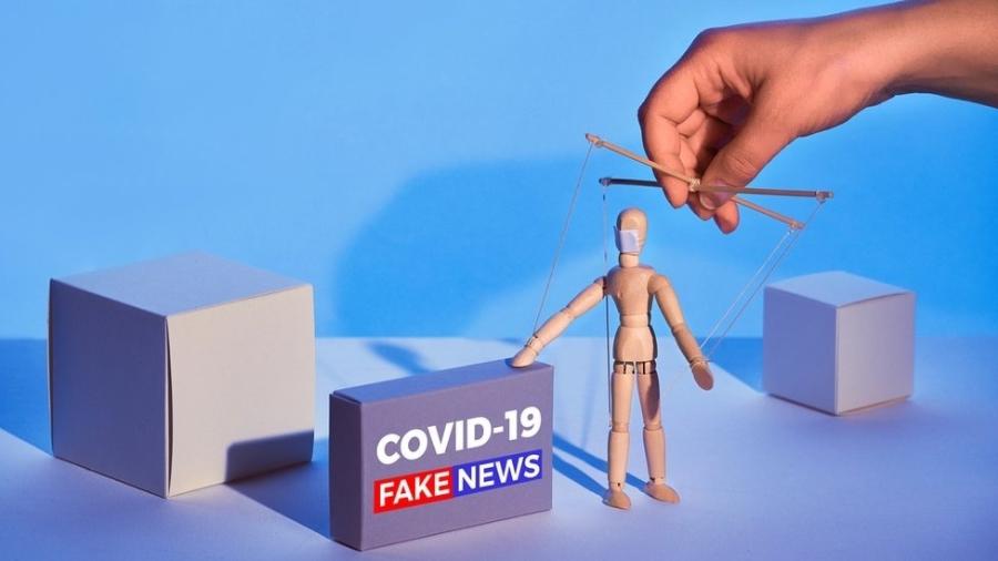 Ilustração gráfica mostra boneco de madeira controlado por mão, como um fantoche, ao lado de caixa que diz: "Covid-19 Fake news" - Getty Images