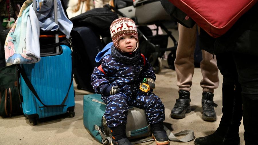 25.fev.2022 - Uma criança senta-se em uma bolsa ao chegar ao vilarejo de Vysne Nemecke, na fronteira da Ucrânia com a Eslováquia - Radovan Stoklasa/Reuters