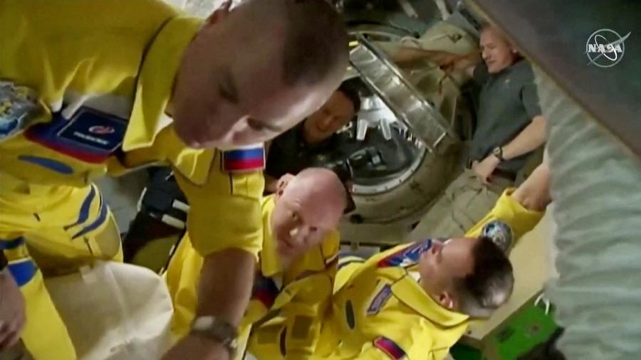 Astronautas russos chegaram à Estação Espacial Internacional vestindo uma roupa amarela com detalhes azuis, as cores da bandeira da Ucrânia - NASA TV/via REUTERS