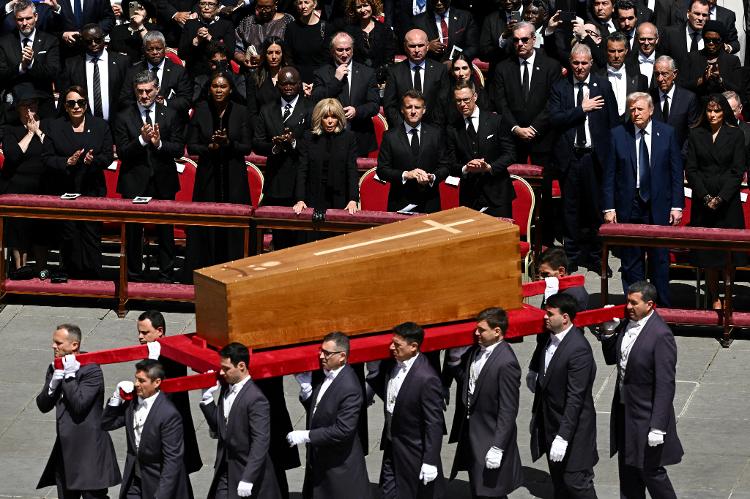 O presidente dos EUA, Donald Trump, a primeira-dama Melania Trump, o presidente francês Emmanuel Macron e sua esposa Brigitte Macron assistem enquanto o caixão do Papa Francisco é carregado pelos carregadores durante sua missa fúnebre na Praça de São Pedro, no Vaticano, em 26 de abril de 2025 O presidente dos EUA, Donald Trump, a primeira-dama Melania Trump, o presidente francês Emmanuel Macron e sua esposa Brigitte Macron assistem enquanto o caixão do Papa Francisco é carregado pelos carregadores durante sua missa fúnebre na Praça de São Pedro, no Vaticano, em 26 de abril de 2025