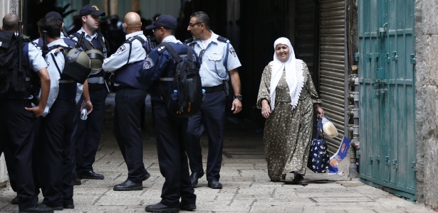 Mulher palestina passa por policiais israelenses na Cidade Velha de Jerusalém - Ahmad Gharabli/AFP