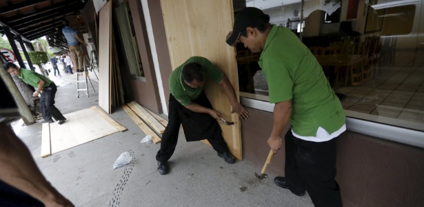 Funcionários de restaurante cobrem janelas com placas de madeira, enquanto o furacão Patricia se aproxima, no balneário de Puerto Vallarta, no Mèxico - Henry Romero/Reuters