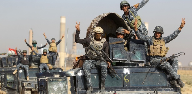 Soldados das forças iraquianas fazem sinal de vitória enquanto passam por campo de petróleo na região de Kirkuk, durante operação contra combatentes curdos - Ahmad al-Rubaye/ AFP