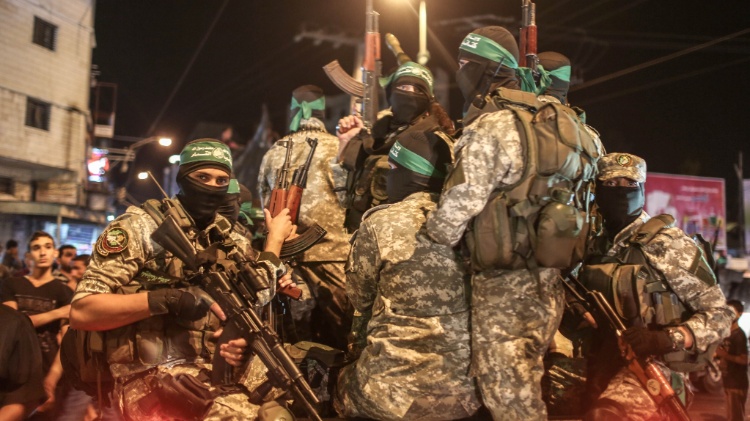 8.jul.2015 - Palestinos da brigada de Ezzedine al-Qassam, braço armado do Hamas, seguram suas armas durante uma marcha militar na cidade de Gaza