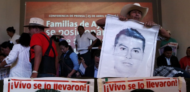 Bernardo Franco, pai de um dos estudantes desaparecidos de Ayotzinapa, segura cartaz com foto do filho e os dizeres "foi levado vivo", na Cidade do México - Ginnette Riquelme/Reuters