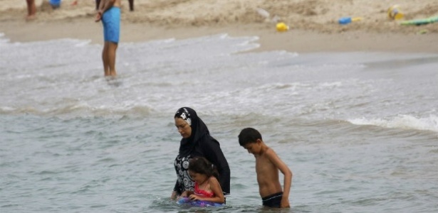 Mulher muçulmana leva seus filhos para nadarem em praia de Marselha, na França - 17.ago.2016/Reuters