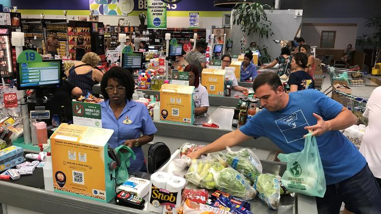 Consumidor empacota suas compras em mercado do Rio de Janeiro; dinheiro na praça pode pressionar a inflação