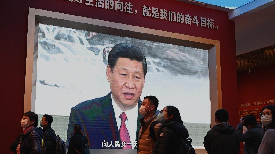 11.nov.2021 - Visitantes caminham em frente a uma tela que mostra o presidente da China, Xi Jinping, no Museu do Partido Comunista da China em Pequim - Noel Celis/AFP