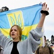 April 30, 2022 - Milena, a refugee from Odessa, carries the Ukrainian flag during a demonstration in Dresden, Germany - Matthias Rietschel / Reuters