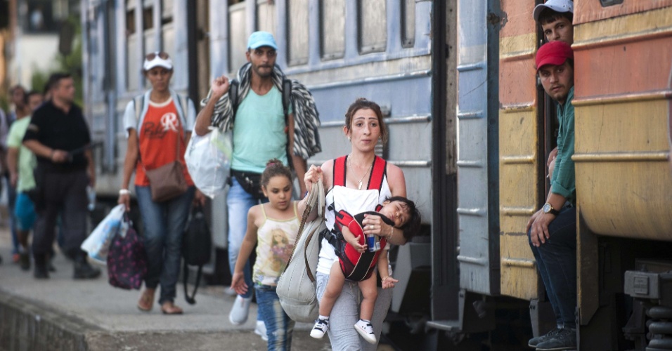 28.jul.2015 - Mulher segura o filho enquanto tenta embarcar em um trem em direção à Sérvia, na estação de trem em Gevgelija, na fronteira entre a Macedônia e a Grécia. Os imigrantes, entre os quais crianças e idosos, tentam cruzar a fronteira entre a Macedônia e a Sérvia para entrar na União Europeia pela Hungria. As autoridades húngaras começaram a construir uma cerca ao longo dos limites do país com a Sérvia no início da semana para barrar o fluxo de imigrantes
