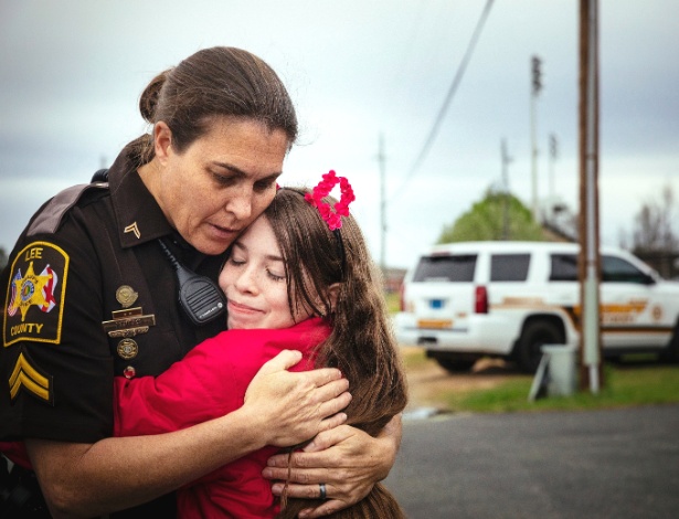 A policial Pamela Revels abraça a estudante Madison Dean, 11, em Smiths Station, no Alabama - Audra Melton/The New York Times