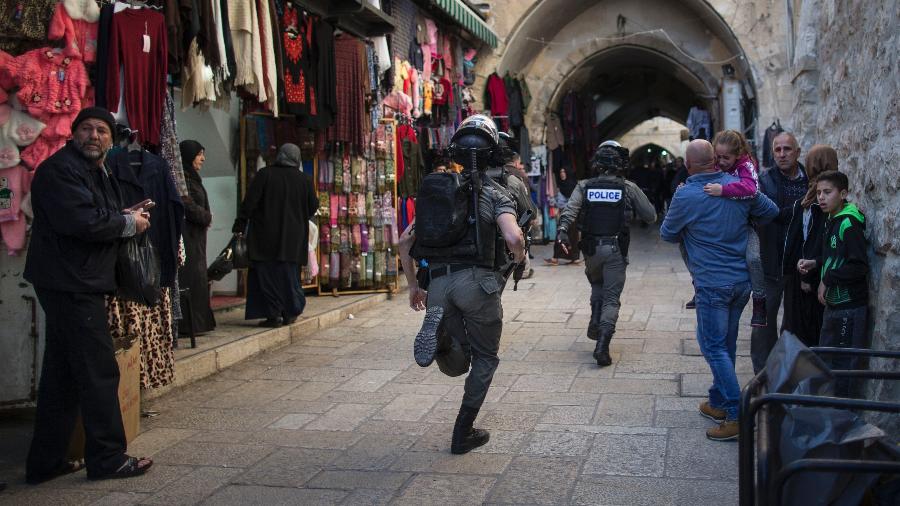 Policiais israelenses perseguem um jovem palestino durante uma manfiestação em Jerusalém - URIEL SINAI/NYT
