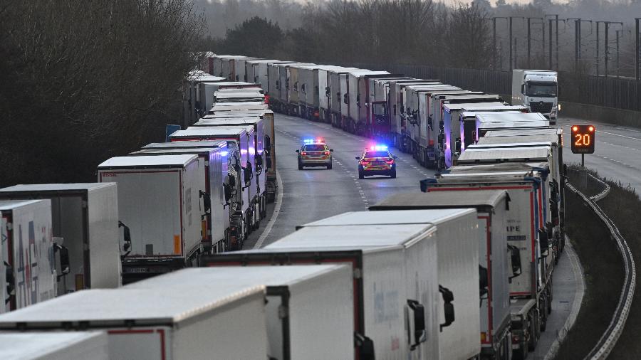 Polícia patrulha rodovia onde centenas de caminhões estão parados devido ao fechamento de fronteiras.A França impediu os caminhões de pegarem a balsa e cruzarem o Canal da Mancha devido à nova mutação do coronavírus - JUSTIN TALLIS / AFP