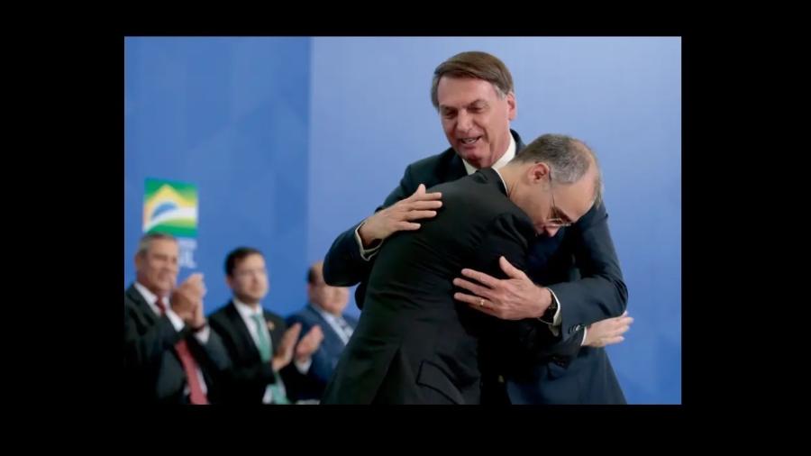 André Mendonça deitado entre o ombro e o peito de Bolsonaro. Essa é uma das imagens que mais se repetem na República. É uma forma de genuflexão sem dobrar os joelhos. Em público ao menos  - Carolina Antunes/PR