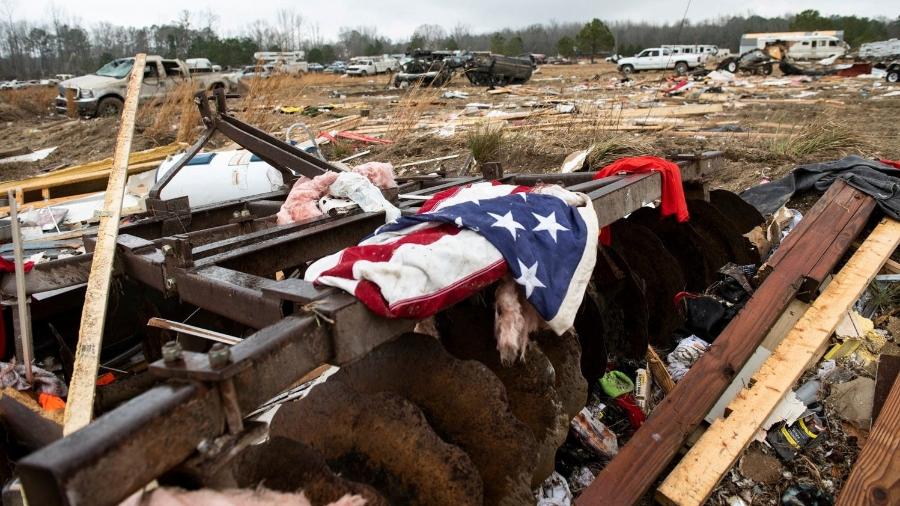 Uma bandeira aparece nos restos de uma casa destruída por um tornado em Old Kingston, no estado de Alabama, EUA - Jake Crandall/Usa Today Network/Via Reuters