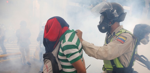 Policial detém manifestante durante ato contra o governo de Nicolás Maduro, em Caracas - Ivan Alvarado/ Reuters