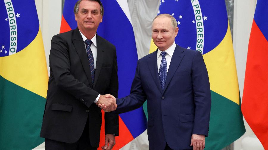 Bolsonaro (à esq.) e Putin apertam as mãos durante visita do brasileiro à Rússia - SPUTNIK/via REUTERS - 16.fev.22