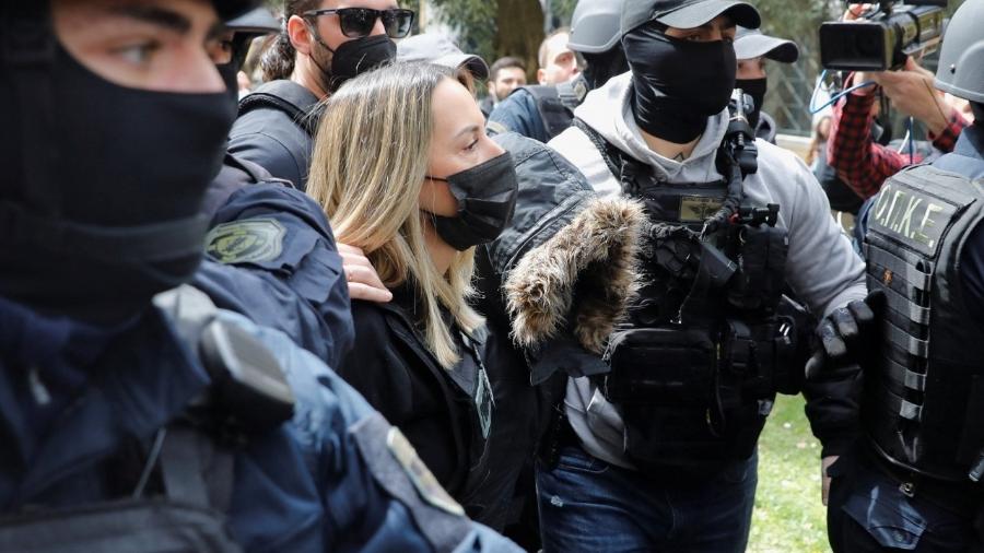 Suspeita sendo escoltada por policiais em Atenas, Grécia - Costas Baltas/Reuters