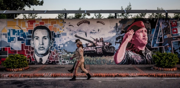 Soldados passam por ilustração de Chávez em Sabaneta, onde o presidente nasceu - Miguel Gutierrez/The New York Times