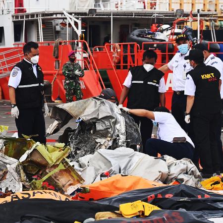 Arquivo - Membros da KNKT examinam destroços do avião da Sriwijaya Air que caiu na Indonésia no dia 9 de janeiro  -  ADEK BERRY / AFP