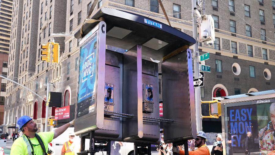 23.mai.22 - Trabalhadores retiram o último telefone público da cidade de Nova York, nos Estados Unidos - TIMOTHY A. CLARY / AFP