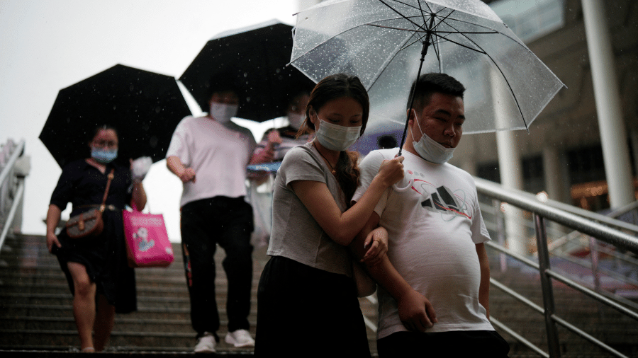 Pedestres andam por Shanghai, na China, em meio a chuva e vento causados pelo tufão Muifa - REUTERS/Aly Song