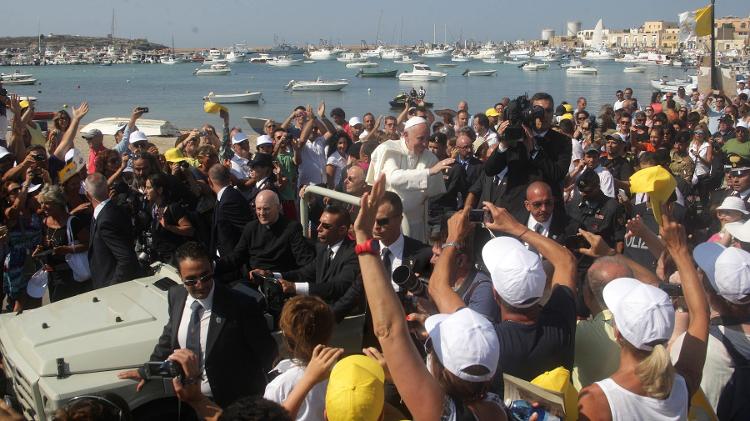 Papa Franscisco acena a fieia ao chegar à ilha de Lampedusa, porta de entrada de imigrantes que chegam à Europa