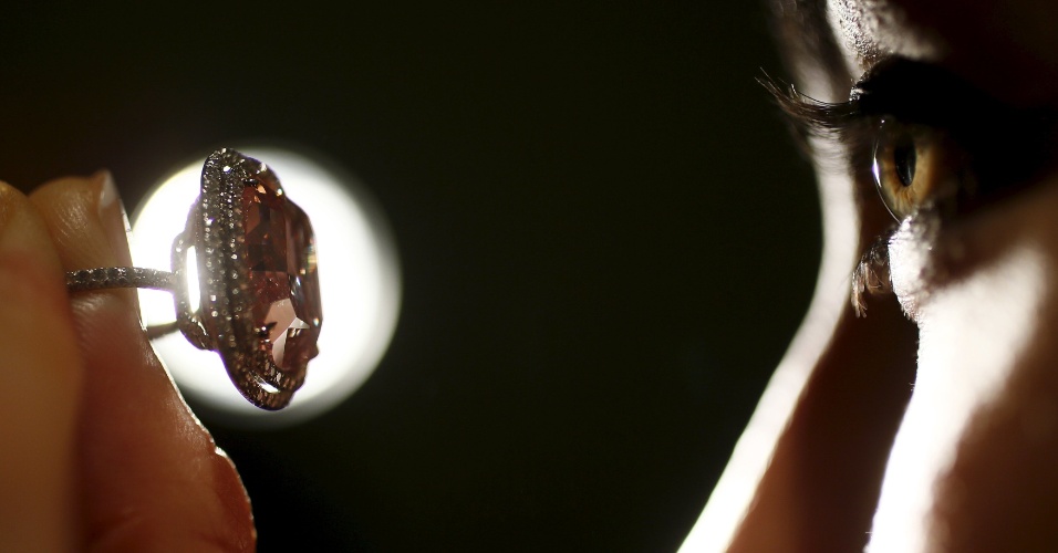 26.out.2015 - Funcionária segura e olha para diamante rosa de 16.08 quilates, na casa de leilões Christie's em Londres, no Reino Unido. A peça pode atingir o valor de 28 milhões de dólares