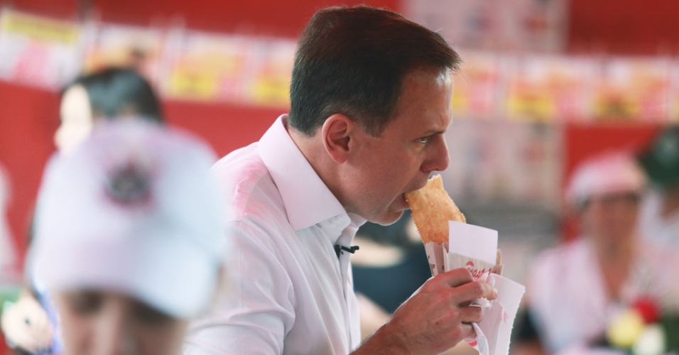 18.ago.2016 - O candidato do PSDB à Prefeitura de São Paulo, João Doria, come pastel em uma feira livre no bairro dos Jardins, zona oeste de São Paulo, durante atividade de campanha