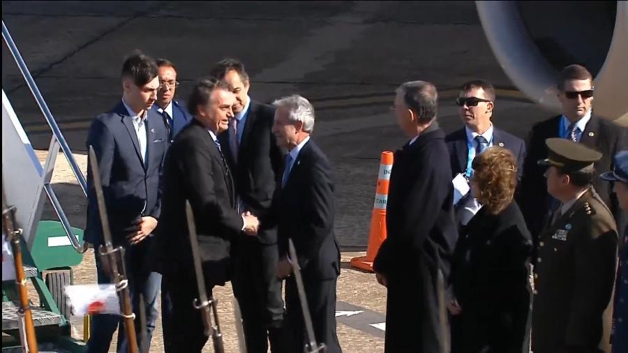 O presidente Jair Bolsonaro é acompanhado de seu filho mais novo, Jair Renan, na chegada à cúpula do Mercosul, em Santa Fé, na Argentina - Reprodução