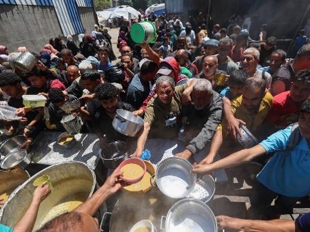 26.abr.2025 - Palestinos em uma fila para conseguirem comida numa cozinha comunitária do Programa Mundial de Alimentos (PMA) da ONU - Eyad BABA / AFP