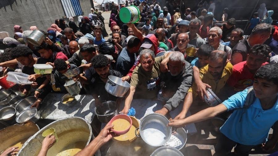 26.abr.2025 - Palestinos em uma fila para conseguirem comida numa cozinha solidária do Programa Mundial de Alimentos (PMA) da ONU - Eyad BABA / AFP