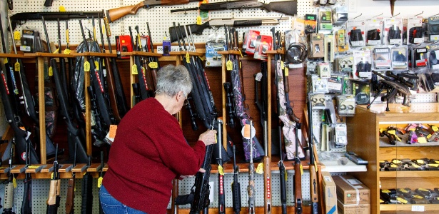 Mulher examina armas em loja no Estado americano do Oregon - Ryan Justin Kang /The New York Times