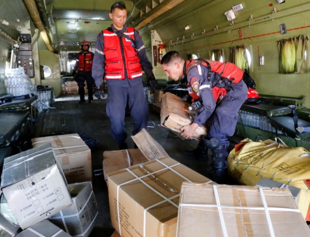 Funcionários carregam avião com donativos para o Haiti no aeroporto de Maiquetia, na Venezuela - Henry Tesara/AVN/Xinhua