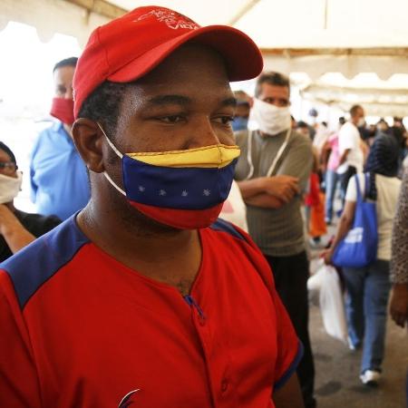 2.mai.2020 - De máscara, homem aguarda para receber cesta básica fornecida pelo governo da Venezuela durante a pandemia do novo coronavírus - Humberto Matheus/NurPhoto via Getty Images