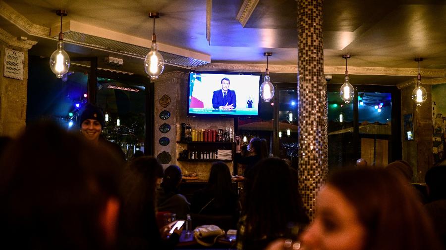 28.out.2020 - Clientes de um café em Paris assistem ao pronunciamento do presidente Emmanuel Macron, que anunciou lockdown de um mês por causa da covid-19  - Martin Bureau/AFP