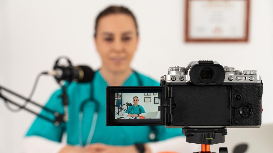 Médica usando câmera para fazer transmissão para o YouTube