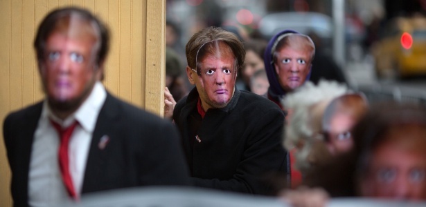 Pessoas usam máscara de Donald Trump durante evento do Dia da Mentira em Nova York  - Kevin Hagen/Getty Images/AFP