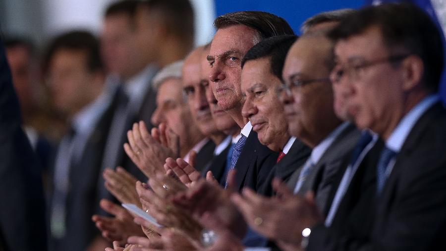 O presidente Jair Bolsonaro, acompanhado do vice presidente Hamilton Mourão e dos ministros Fernando Azevedo e Silva (Defesa) e Abraham Weintraub (Educação), e do governador do DF Ibaneis Rocha, dentre outros, durante cerimônia de lançamento do Programa Nacional de Escolas Cívico-Militares, no Palácio do Planalto -  Pedro Ladeira/Folhapress