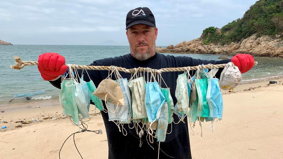 Gary Stokes, fundador do grupo pela conservação marinha OceansAsia, mostra máscaras coletadas em praia de Hong Kong - REUTERS