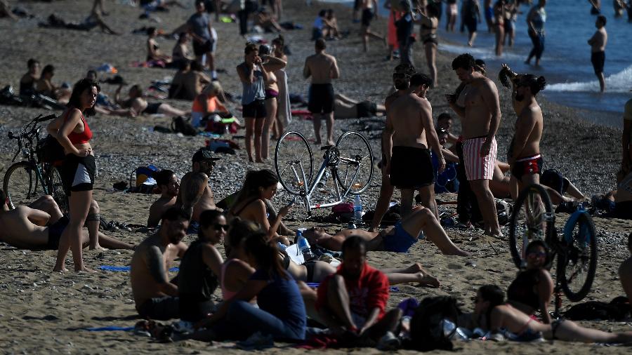 Banhistas aproveitam sol em praia na região de Barceloneta, um dos bairros mais populares de Barcelona - LLUIS GENE / AFP