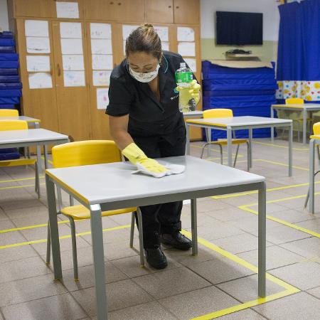 14 jan. 2021 - Funcionária limpa mesas em uma escola municipal na zona sul de São Paulo - Tiago Queiroz/Estadão Conteúdo