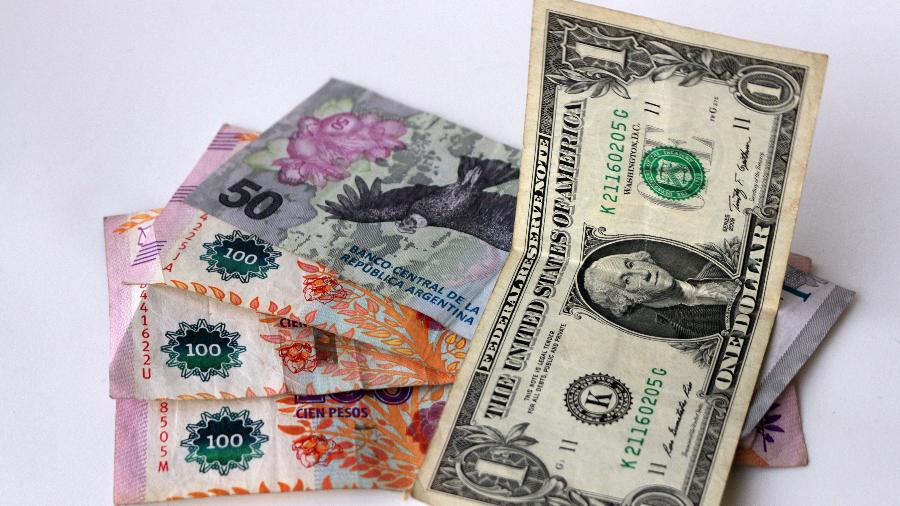 Nota de dólar e pesos argentinos - Carol Smiljan/NurPhoto via Getty Images