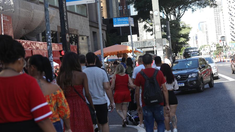 Pedestres disputam espaço com ambulantes na calçada após a suspensão do Ruas Abertas, que restringe a circulação de carros na Avenida Paulista