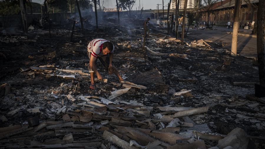 Homem tenta resgatar pertences em meio a escombros de incêndio na favela do Cimento, na zona leste de São Paulo - Danilo Verpa/Folhapress