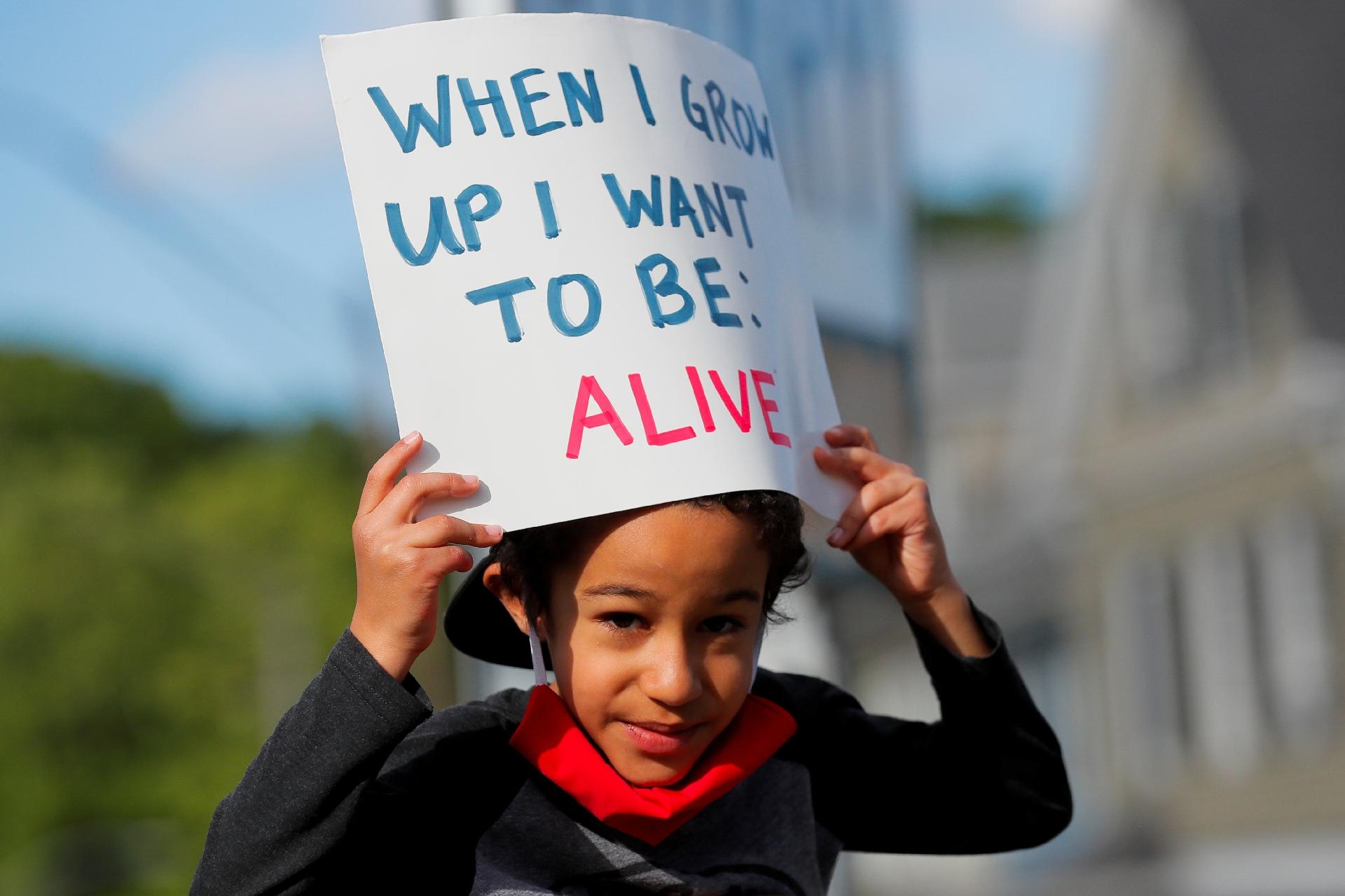 Adam Neves, 6 anos, segura um cartaz escrito "quando eu crescer, quero estar vivo" durante um protesto após a morte de George Floyd, em Boston, Massachusetts - BRIAN SNYDER/REUTERS